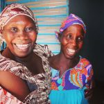 Two women in Senegal smiling, in a Tostan partner community