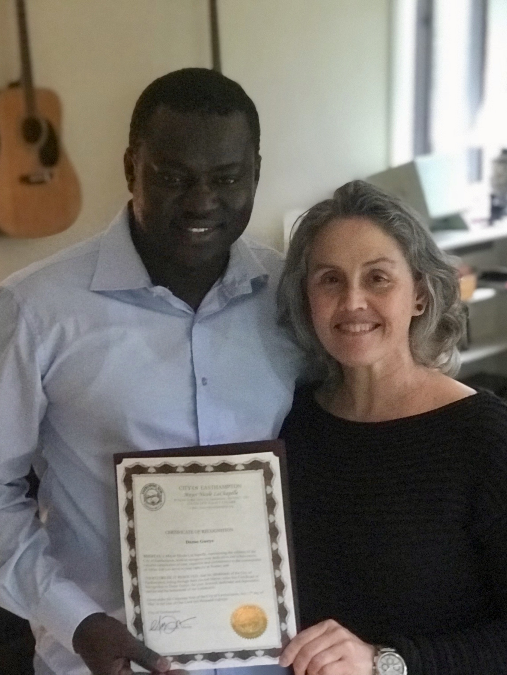 Dame Guèye receiving a certificate of recognition from Nicole Lachapelle, Mairesse of Easthampton